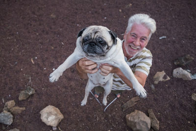 Senior man holding pug