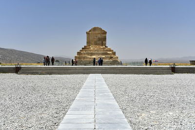 Tourists at temple against clear sky