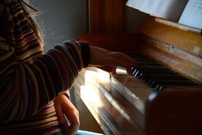 Midsection of woman playing piano