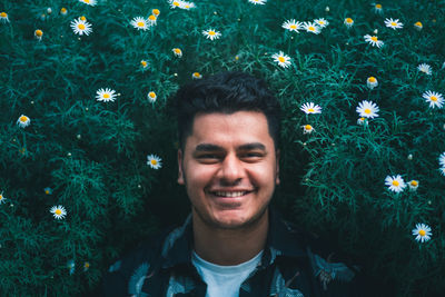 Portrait of smiling young man against plants