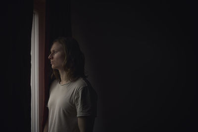 Thoughtful man looking through window