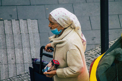 Side view of woman holding umbrella