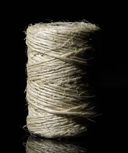 Close-up of rope tied up on wood against black background