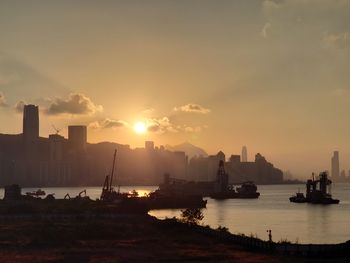 Silhouette boats in bay against sky during sunset