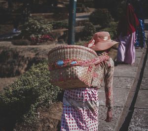 Rear view of woman carrying basket