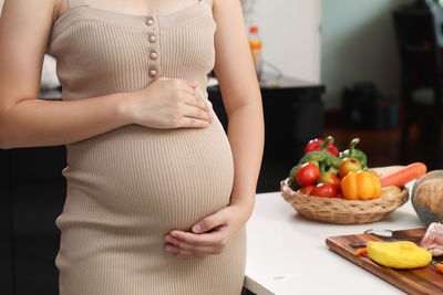 Midsection of woman standing on cutting board