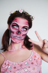 Portrait of young woman with eyes closed against wall