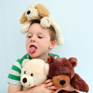 Portrait of cute boy with toy against white background