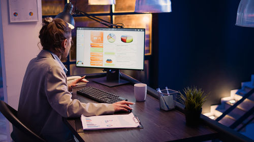 Midsection of woman using laptop on table