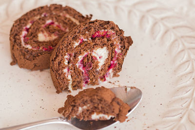 Homemade sweet chocolate roll with cream and raspberry.