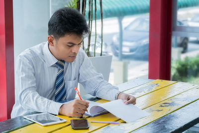 Businessman with looking at documents on table in office