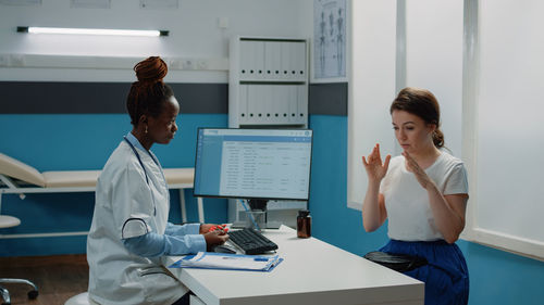 Doctor wearing mask examining patient in clinic