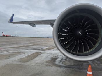 Close-up of airplane on airport runway against sky