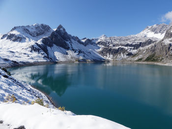 Scenic view of lake and snowcapped mountains against sky