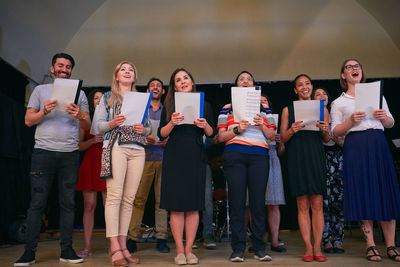 Multi-ethnic people singing at choir practice in school