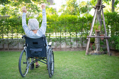 Rear view of woman sitting in park