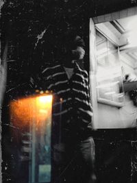 Reflection of woman on glass window at night