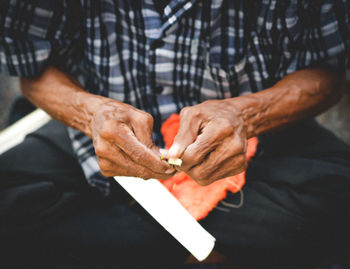 Midsection of man working on wicker