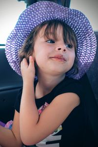 Cute girl looking away while sitting in car