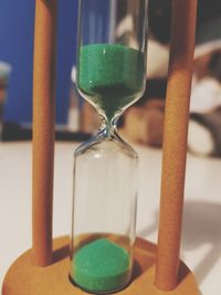 Close-up of hourglass with green sand