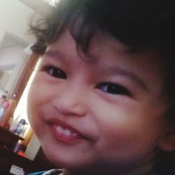 Close-up portrait of smiling girl at home