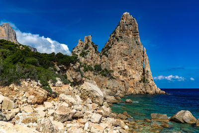 Rock formations in sea against sky