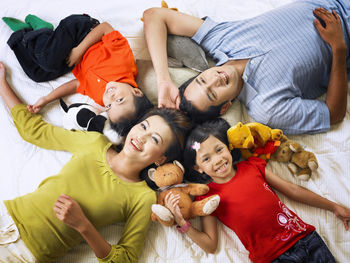 High angle portrait of happy family lying on mattress at home