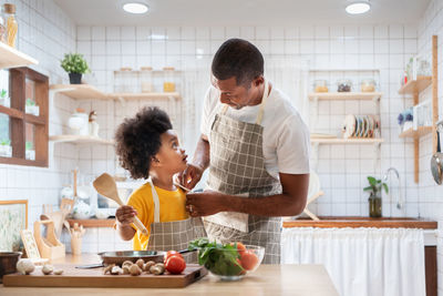 Father and son preparing foood in kitchen at home