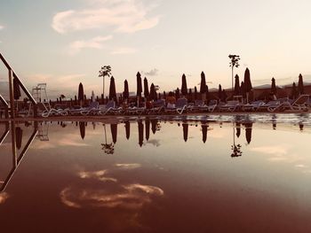 Sailboats in sea against cloudy sky