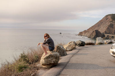 Woman sitting on rock at big sur view point