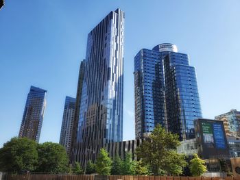 Low angle view of modern buildings against clear blue sky