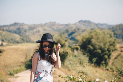 Woman standing on mountain during sunny day