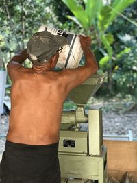 Rear view of man working on plant