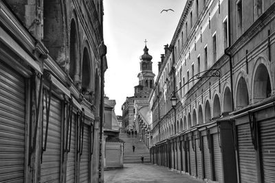 Alley amidst buildings in city against clear sky