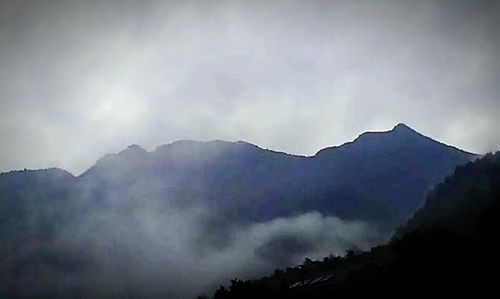 Scenic view of mountains against cloudy sky