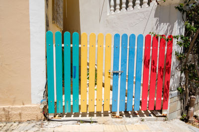 Multi colored fence against built structure