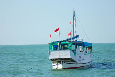 Sailboat in sea against clear sky