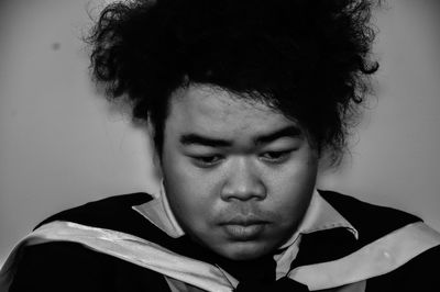 Close-up portrait of young man against gray background