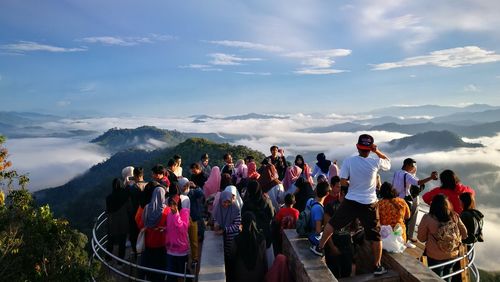 People standing on mountain against sky