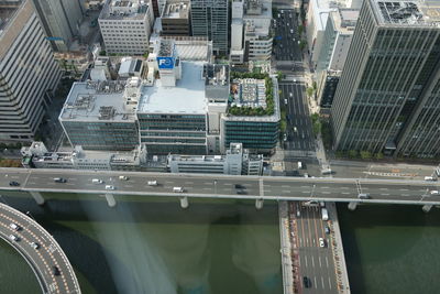 Aerial view of elevated road over river by buildings in city