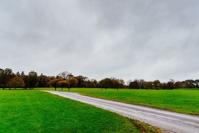 Green gardens of muckross house in killarney against cloudy sky.