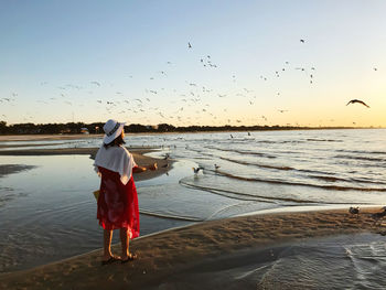 Full length of woman on beach during sunset