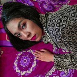 Portrait of beautiful woman lying on carpet