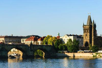 Arch bridge over river against buildings in city