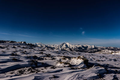 Scenic view of snow mountains against blue sky