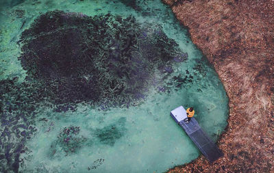 High angle view of man on rock in sea