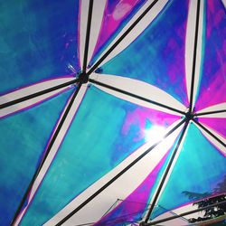 Low angle view of multi colored umbrella against blue sky