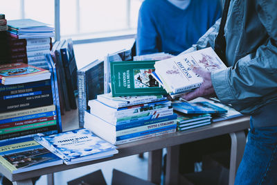 Midsection of people with books at table