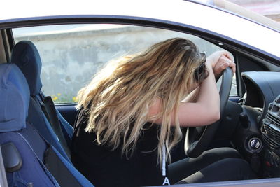 Rear view of woman sitting in car