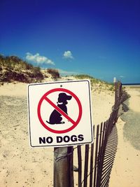 Road sign on shore against clear sky